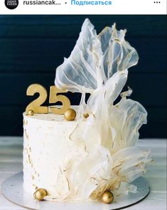 a white cake with gold decorations and the number twenty five