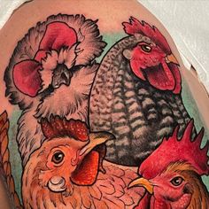 a close up of a person's arm with tattoos on it and roosters