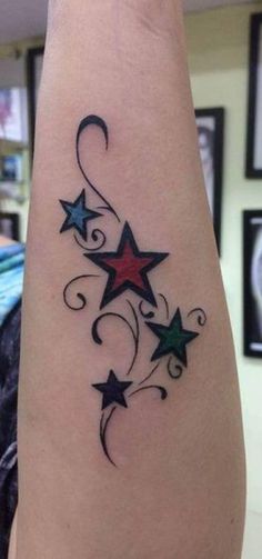 a woman's arm with stars and swirls tattoo on the back of it