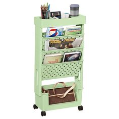 a green shelf with magazines and other items on it's sides, sitting against a white background