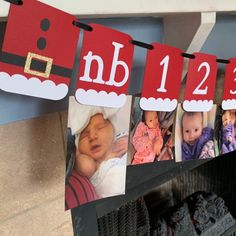 a christmas card hanging from a clothes line with pictures of babies in santa's hat