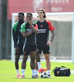 three soccer players are standing on the field with their hands in their pockets and one is holding his mouth open