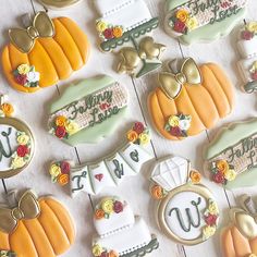 some decorated cookies are sitting on a white table with pumpkins and other decorations around them