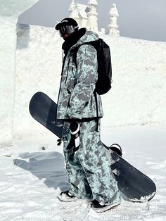 a snowboarder is walking in the snow with his board