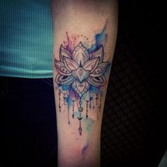 a woman's arm with a watercolor tattoo design on the left side of her leg