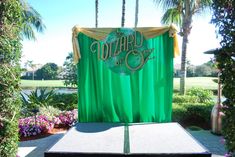 a stage set up for a party with green drapes and the word wizard on it