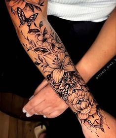 a woman's arm with flowers and butterflies on it