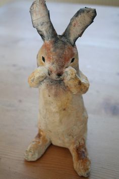 a ceramic rabbit figurine sitting on top of a wooden table