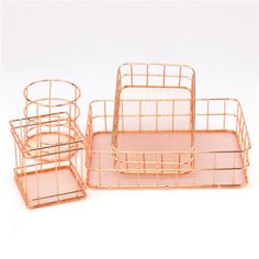 three gold metal baskets with handles on each side and one in the middle, sitting next to each other