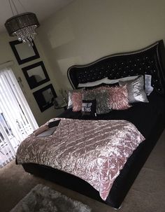 a bedroom with a large bed and chandelier