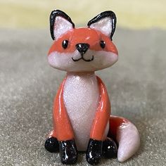 a small toy fox sitting on top of a carpet