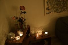 candles and flowers on a table in a dimly lit room