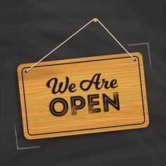 we are open sign hanging on a chalkboard with the words we are open written on it