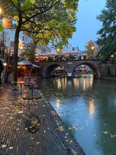 people sitting at tables on the side of a river