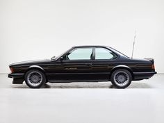 a black car parked in a white room