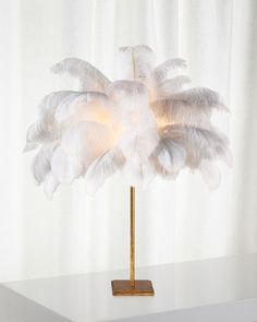 a lamp that is on top of a table with a white curtain in the background