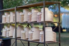 several stacks of white plates sitting on top of a metal rack