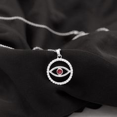 Product Details The Evil Eye Pendant is a striking piece of jewelry that exudes just the perfect level of allure and makes an excellent present for someone special. The Eternity Pendant Necklace showcases a Round Shape Ruby that sits in a Bezel Setting at the center of the Eternity Circle. The circle is embellished with Brilliant Cut Diamond, creating a stunning and refined appearance. Wearing this pendant will elevate your outfit and bring a touch of sophistication to your overall look. Product Symbolic Birthstone Jewelry For Wedding, Symbolic Wedding Jewelry With Birthstone, Symbolic Red Jewelry For Anniversary, Symbolic Diamond Jewelry With Gemstones, Spiritual Round Diamond Jewelry, Symbolic Round Cubic Zirconia Jewelry, Symbolic Round Diamond Jewelry, Symbolic Round Gemstone Jewelry, Infinity Halo Jewelry Gift