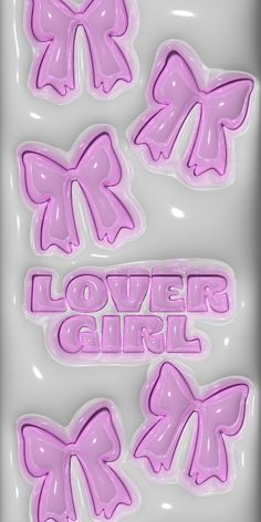 some pink bows and the words lover girl on them are in front of a white background