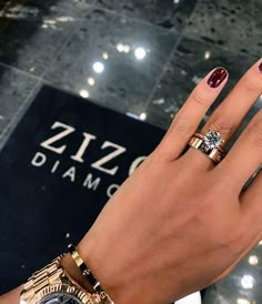 a woman's hand with two different rings on it and a diamond ring in the middle