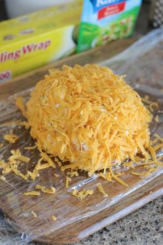 shredded cheese sitting on top of a wooden cutting board