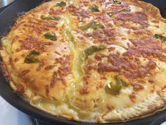 a pizza sitting on top of a pan covered in cheese and green pepper toppings