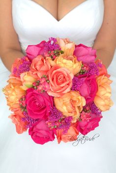 a bridal holding a bouquet of pink and orange flowers on her wedding day,