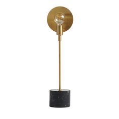 a black and gold lamp with a marble base on a white background the light is dim