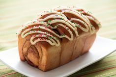 a piece of bread with icing and sprinkles on a white plate