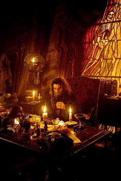 a man sitting at a table with candles in front of him