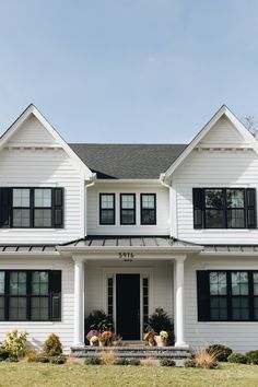 a large white house with black shutters and windows