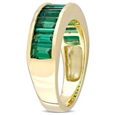 This gorgeous semi-eternity ring is crafted in lustrous yellow plated sterling silver. This pretty stackable anniversary band features nine baguette-cut created emerald gemstones beautifully arranged in a channel setting with 2 3/4ct tgw. Enhanced with a high polish finish, this wedding band will make a standout addition to any jewelry collection. This stunning ring is a perfect gift for the woman with a unique and trendy sense of style. Emerald Anniversary, Ornate Ring, Emerald Band, Channel Setting, Lab Created Emerald, Peoples Jewellers, Elegant Ring, Emerald Gemstone, Baguette Cut