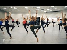 a group of people in a dance studio doing different poses with their arms up and legs apart