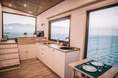 a kitchen area with sink, stove and window overlooking the ocean