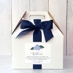 a small white box with a blue ribbon on it