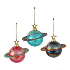 three ornaments are hanging in the shape of saturn