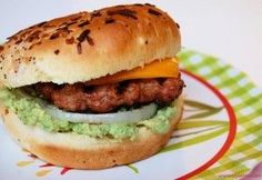 a hamburger with meat, cheese and guacamole