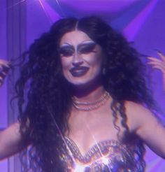 a woman with long hair and makeup on stage