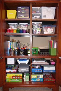 a bookcase filled with lots of books and plastic containers on top of wooden shelves