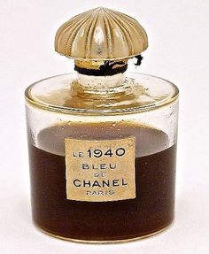 a small glass jar filled with brown liquid and a gold lid on top of it