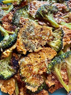 broccoli florets and other vegetables on a blue plate with seasoning