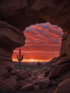 the sun is setting behind a large rock formation with a cactus in the foreground