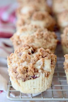 several muffins cooling on a wire rack, with crumbs and icing