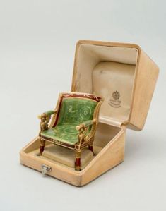 a miniature chair sitting inside of a wooden box