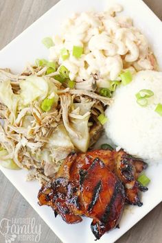 a white plate topped with meat, rice and veggies