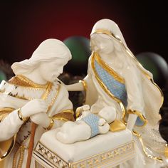 a nativity scene with two figurines sitting next to each other