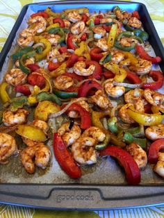 a pan filled with shrimp and peppers on top of a table