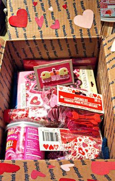 an open cardboard box filled with valentine's day treats and candy bar wrappers