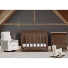 a baby crib and rocking chair in a room with gray walls, white carpet and wooden flooring