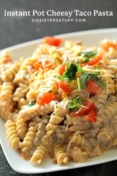 a white plate topped with pasta covered in meat and vegtables on top of it